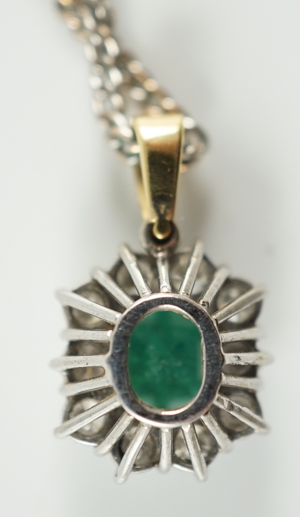 An 18ct white and yellow gold, emerald and diamond set shaped rectangular cluster pendant, on a 9ct white gold chain